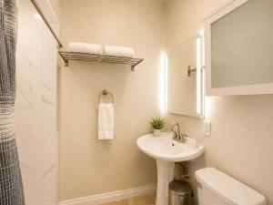 a white bathroom with a sink and a shower at 2BR with patio, grill, central AC, enclosed yard in Hollywood +10 photos