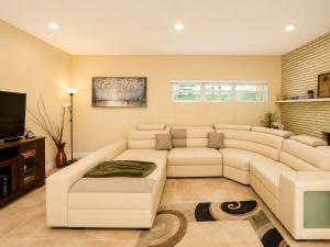 a living room with a white couch and a television at 2BR with patio, grill, central AC, enclosed yard in Hollywood