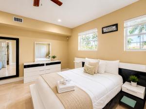 a bedroom with a large bed and two windows at 2BR with patio, grill, central AC, enclosed yard in Hollywood