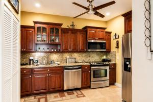 a kitchen with wooden cabinets and stainless steel appliances at 2BR with patio, grill, central AC, enclosed yard in Hollywood