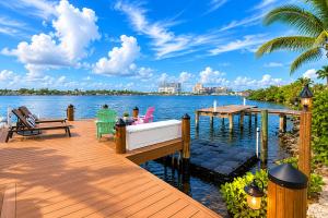 a wooden dock with a boat on the water at 2BR with patio, grill, central AC, enclosed yard in Hollywood