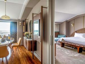 a hotel room with a bed and a dining room at The Artisan Hotel Istanbul - MGallery Collection in Istanbul