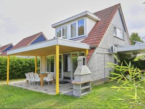 a house with a patio with a table and chairs at Villa Christina in Stevensweert