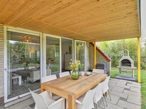 a wooden table and chairs on a patio at Villa Christina in Stevensweert