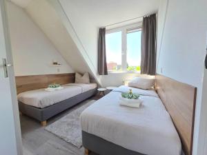 a small room with two beds and a couch at Villa Christina in Stevensweert