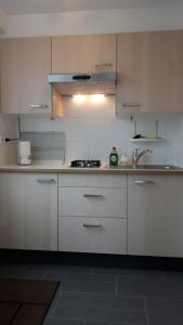 a kitchen with white cabinets and a sink at FlipFlop in Noordwijk aan Zee
