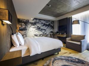 a bedroom with a large bed and a chair at Mercure Riga Centre in Riga +123 photos