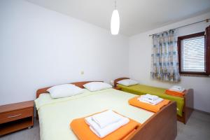a bedroom with a bed with two towels on it at Apartments and rooms by the sea Jakisnica, Pag - 4160 in Lun