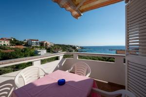a balcony with a table and chairs and the ocean at Apartments and rooms by the sea Jakisnica, Pag - 4160 in Lun