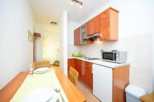 a small kitchen with a table and a microwave at Apartments and rooms by the sea Jakisnica, Pag - 4160 in Lun
