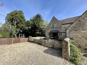 a house with a wooden fence in front of it at The Old Coach house- a delightful home from home in Witney