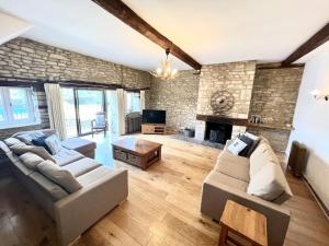 a living room with two couches and a fireplace at The Old Coach house- a delightful home from home in Witney