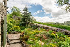 a garden with flowers and a road at 2 Bed in Buxton oc-dcbap in Longnor +13 photos
