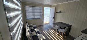 a small room with a table and chairs and a window at Apart Hotel Cecil in Vallenar