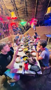 a group of people sitting at a long table at Hakuna Matata Hostel in Sigiriya