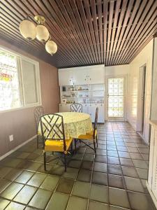 a dining room with a yellow table and chairs at Maresia Beach House in Rio das Ostras