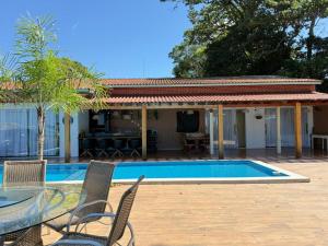 a patio with a table and chairs next to a pool at Maresia Beach House in Rio das Ostras