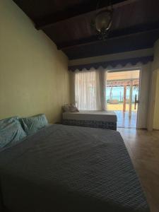 a bedroom with a large bed and a window at Maresia Beach House in Rio das Ostras