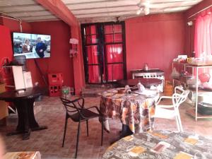 a red room with a table and chairs and a tv at HOSPEDAJE DODERA in Gualeguaychú