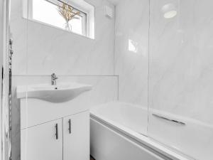 a white bathroom with a sink and a shower at LODGEselect in Thamesmead