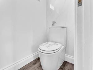 a white bathroom with a toilet in a room at LODGEselect in Thamesmead