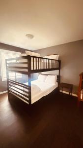 a bedroom with a bunk bed with white sheets and pillows at Wavy Daze in Wasaga Beach in Wasaga Beach