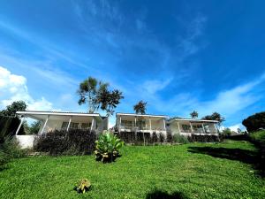 a house on a green lawn with a blue sky at Cabin Inn by Batu Pineus in Pengalongan