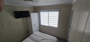 a small bedroom with a bed and a window at Apart Hotel Cecil in Vallenar