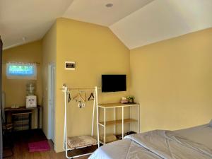 a bedroom with a bed and a tv on the wall at Cabin Inn by Batu Pineus in Pengalongan