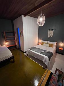 a bedroom with a large bed and a chandelier at Caju com Mel Hospedagem in Moreré