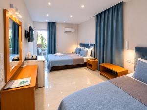 a hotel room with two beds and a television at Castro Hotel in Amoudara Herakliou +139 photos