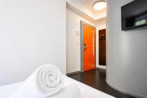 a room with a bed and a tv on a wall at easyHotel Zürich City Centre in Zurich