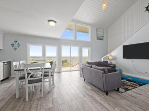 a living room with a table and a couch and a television at Oceanfront vacation home - EAST in Emerald Isle