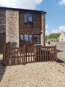 a wooden fence in front of a house at Mill View-an idyllic base to explore The Cotswolds in Northleach