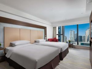 two beds in a hotel room with a large window at Novotel Nanjing Central in Nanjing +74 photos