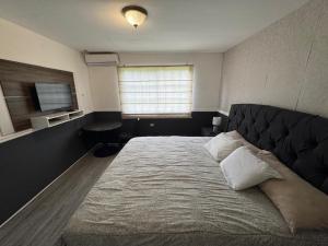 a bedroom with a large bed and a window at Beautiful Luxe Apartment in Chitré