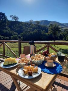 a picnic table with bread and other foods on it at Chalé Águas Claras in Capitólio
