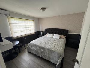 a bedroom with a bed and a desk and a window at Beautiful Luxe Apartment in Chitré