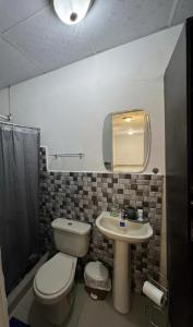 a bathroom with a toilet and a sink and a mirror at Beautiful Luxe Apartment in Chitré