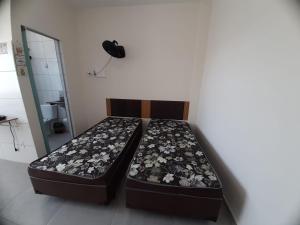 two beds sitting next to each other in a room at Flat em Varginha, Minas Gerais com Lazer Total e Estacionamento Gratuito in Varginha +27 photos
