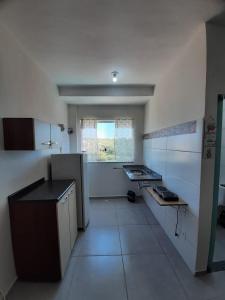 an empty kitchen with a sink and a window at Flat em Varginha, Minas Gerais com Lazer Total e Estacionamento Gratuito in Varginha