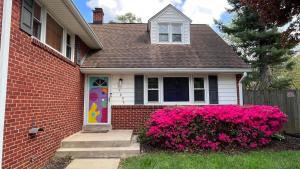a house with a colorful door and pink flowers at Casa Pinturella in Silver Spring