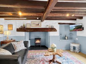 a living room with a couch and a fireplace at Bobs Cottage Porlock Weir in Porlock