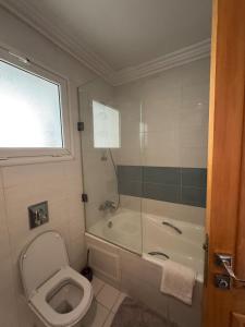 a bathroom with a toilet and a tub and a shower at Résidence Tasnim Ennasr in Ariana