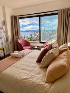 a bedroom with a large bed with a large window at Studio Mirador in San Carlos de Bariloche
