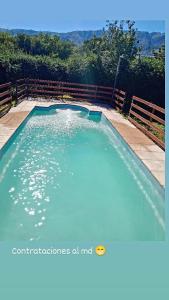 a swimming pool with blue water in a yard at Departamento Fede 1 in Carpintería