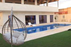 a swing in front of a swimming pool at شاليهات ذهب in Amman