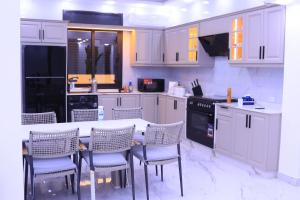 a kitchen with white cabinets and a table and chairs at شاليهات ذهب in Amman