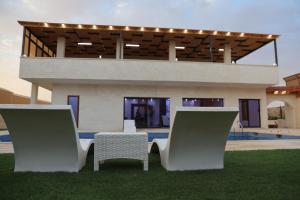 two chairs and a table in front of a house at شاليهات ذهب in Amman