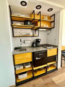 a kitchen with wooden cabinets and a sink at Studio Mirador in San Carlos de Bariloche +3 photos